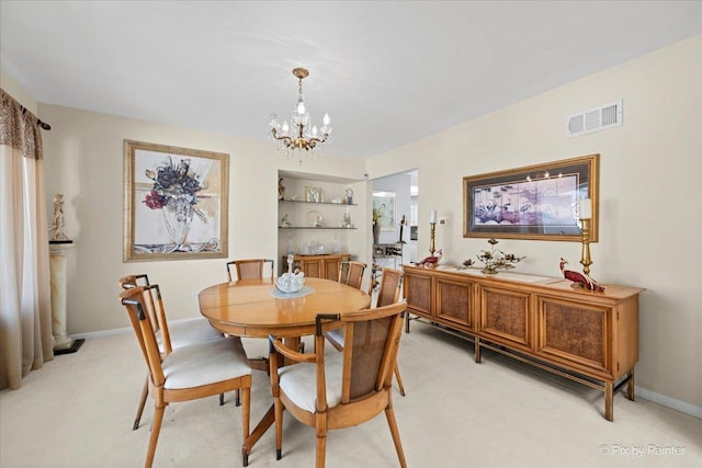 dining space with light colored carpet, visible vents, a notable chandelier, and baseboards