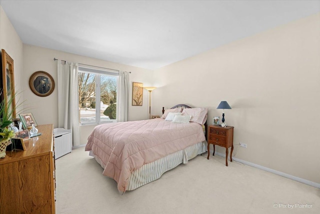 bedroom with light colored carpet and baseboards