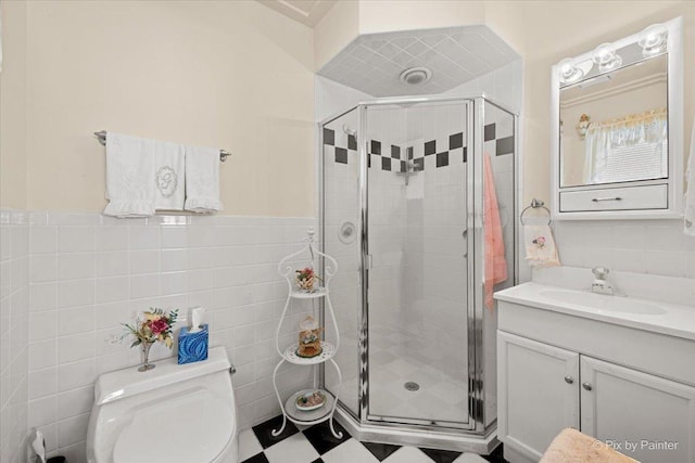 full bath featuring toilet, a shower stall, tile walls, and vanity