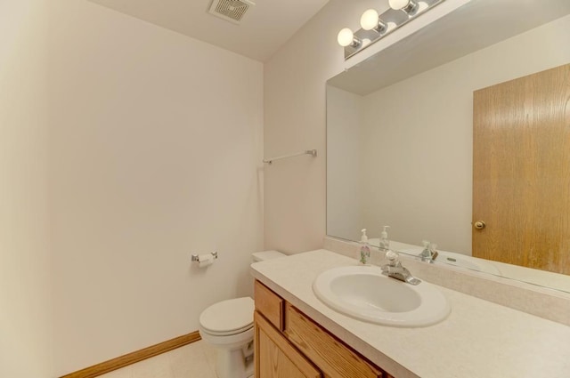 half bath with tile patterned floors, visible vents, toilet, baseboards, and vanity