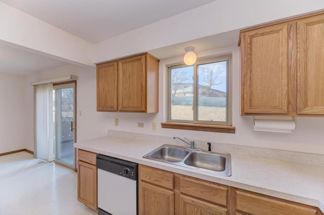 kitchen with a sink, dishwasher, brown cabinetry, and light countertops