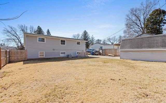 back of property with a lawn and a fenced backyard