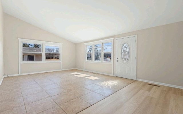 foyer entrance featuring baseboards and lofted ceiling