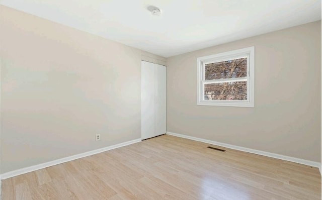 empty room with visible vents, baseboards, and light wood-style flooring