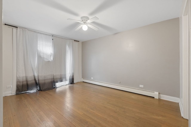 unfurnished room featuring a baseboard heating unit, ceiling fan, and wood finished floors