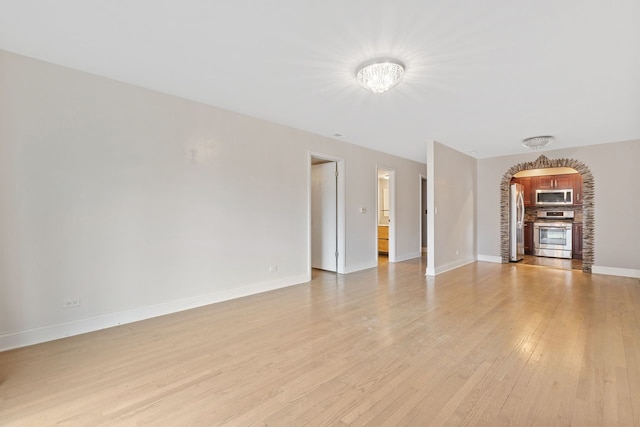 unfurnished living room with light wood-style flooring and baseboards