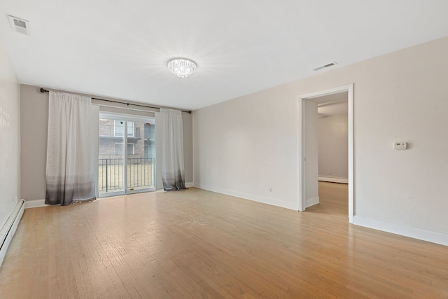 spare room featuring visible vents, baseboard heating, light wood-type flooring, and a baseboard radiator