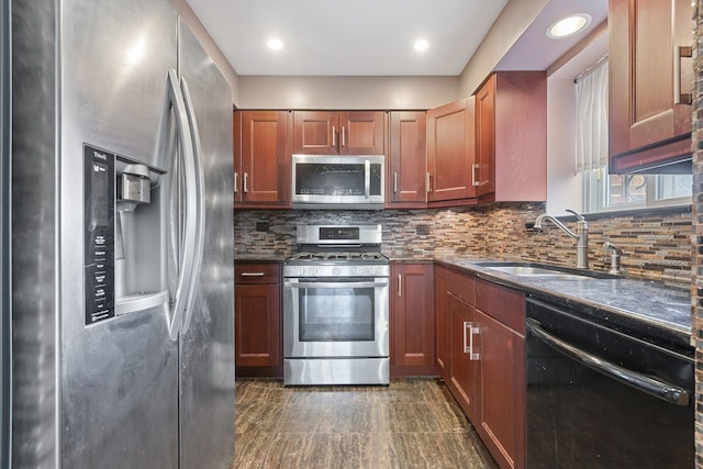 kitchen with dark stone countertops, tasteful backsplash, appliances with stainless steel finishes, and a sink