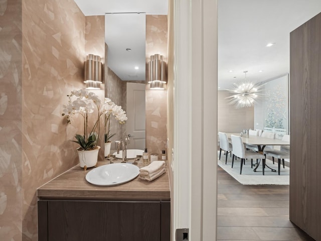 bathroom featuring vanity, recessed lighting, wood finished floors, and a chandelier