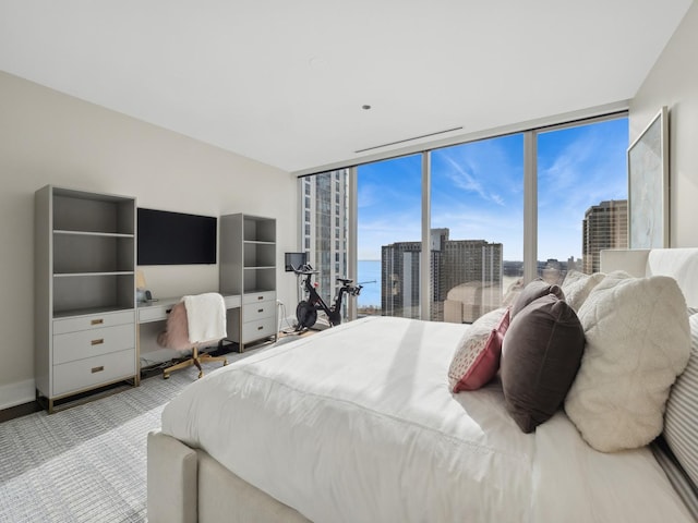 carpeted bedroom with a wall of windows and baseboards