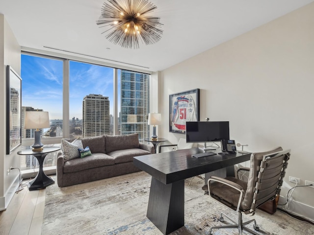 office featuring expansive windows, baseboards, an inviting chandelier, and wood finished floors