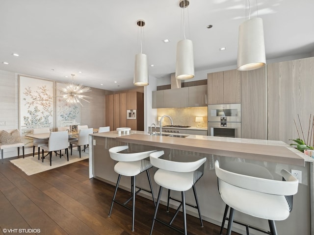 kitchen with tasteful backsplash, dark wood-type flooring, double oven, light countertops, and modern cabinets