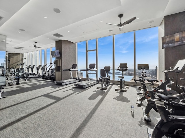 workout area with a wall of windows, a ceiling fan, visible vents, and carpet floors