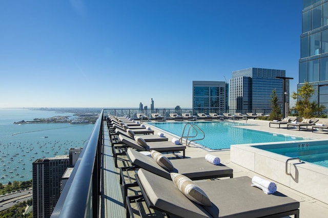 community pool with a view of city, a patio, and a water view