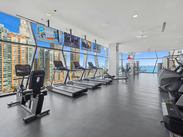 gym with visible vents, a ceiling fan, and expansive windows