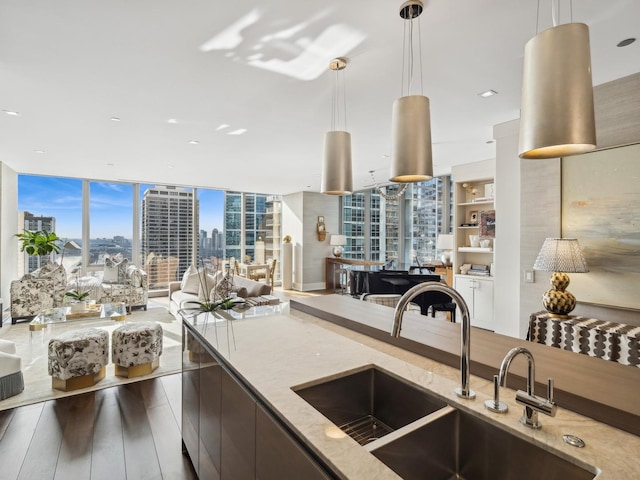 kitchen featuring open floor plan, a view of city, a wall of windows, and a sink