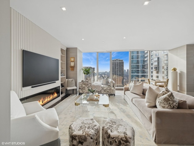 living room featuring recessed lighting, floor to ceiling windows, built in shelves, and a large fireplace