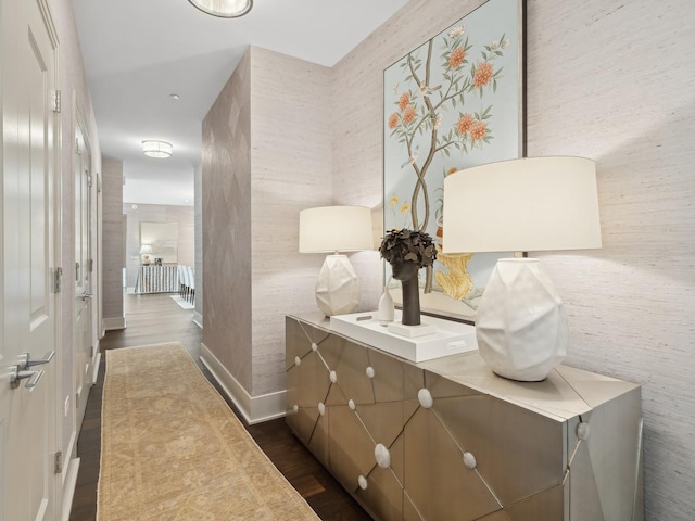 corridor featuring dark wood finished floors and baseboards