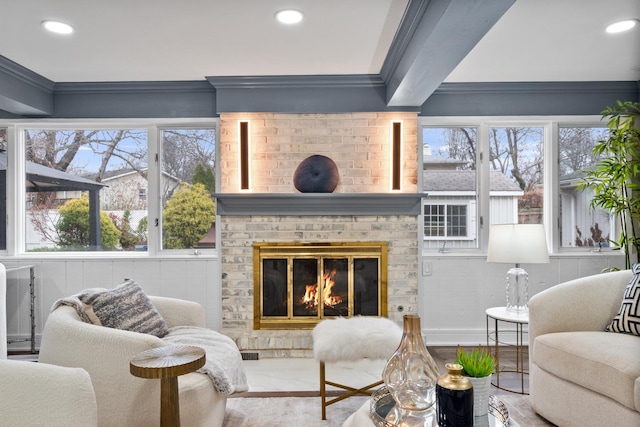 living room featuring ornamental molding, recessed lighting, and a brick fireplace