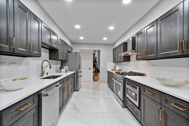 kitchen with a sink, light countertops, appliances with stainless steel finishes, wall chimney range hood, and marble finish floor