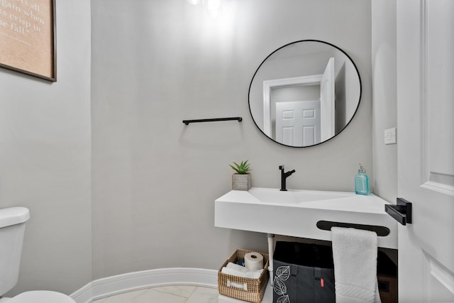 half bath featuring marble finish floor, baseboards, and toilet