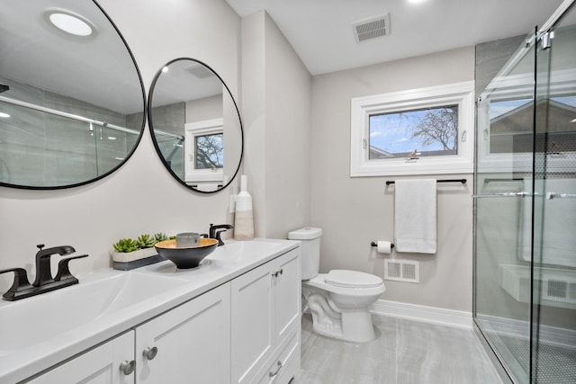 bathroom with toilet, a shower stall, visible vents, and a sink