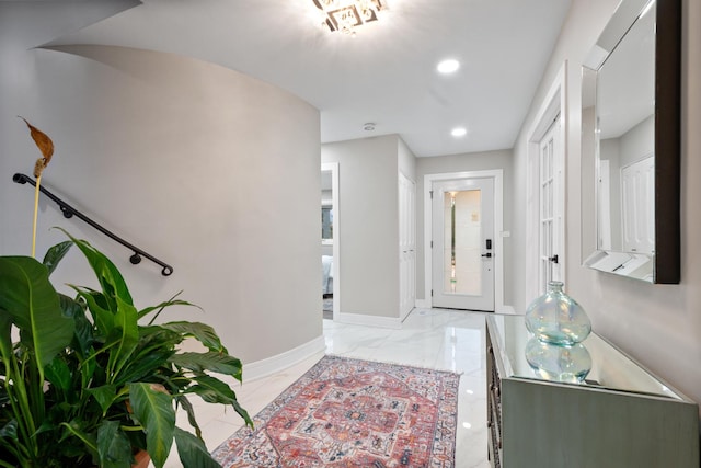 foyer entrance featuring marble finish floor, baseboards, and recessed lighting