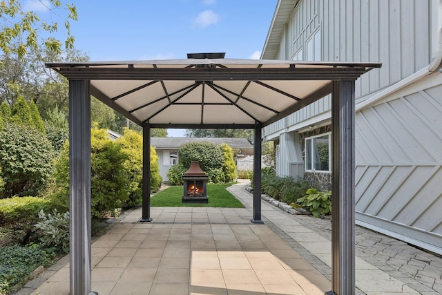 view of vehicle parking featuring a warm lit fireplace and a gazebo