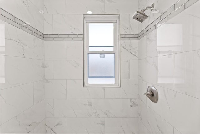 bathroom with a healthy amount of sunlight and tiled shower