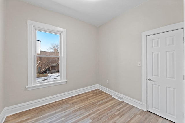 spare room featuring light wood-style flooring and baseboards