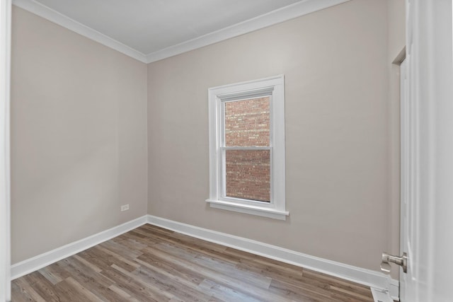 unfurnished room with light wood-style flooring, baseboards, and ornamental molding