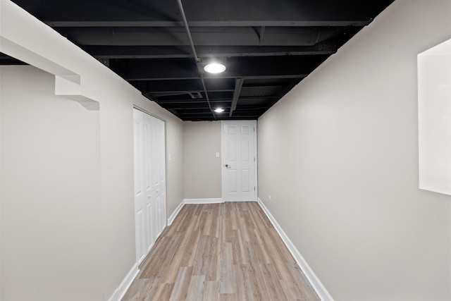 finished below grade area with light wood finished floors and baseboards