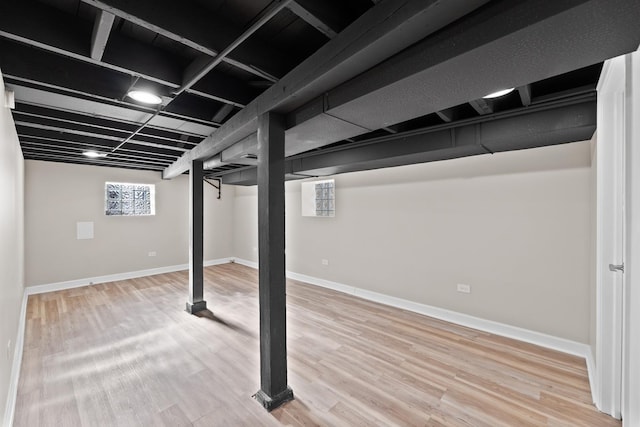 basement featuring baseboards and wood finished floors