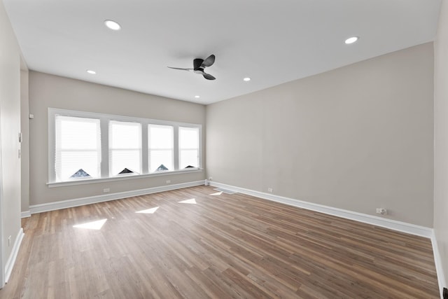 empty room with a ceiling fan, baseboards, wood finished floors, and recessed lighting