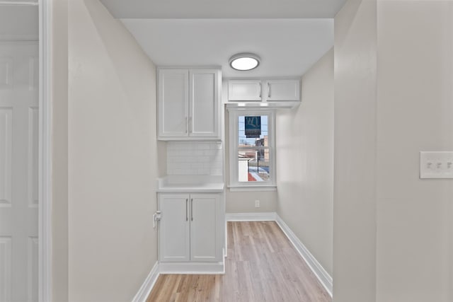 interior space with baseboards and light wood finished floors