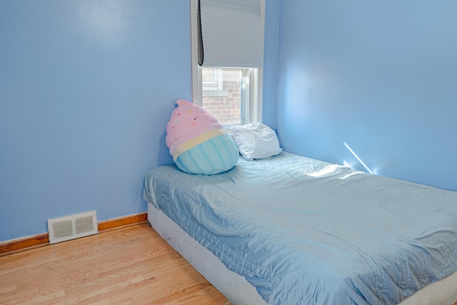 bedroom with baseboards, visible vents, and light wood-style floors