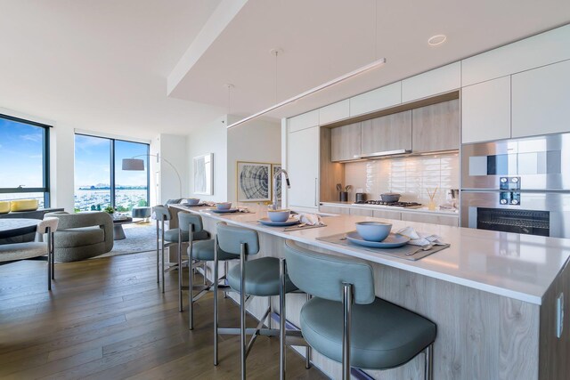 211 N Harbor Dr Unit 1502, Chicago, IL 60601 - kitchen with a breakfast bar, dark wood finished floors, decorative backsplash, modern cabinets, and a wall of windows