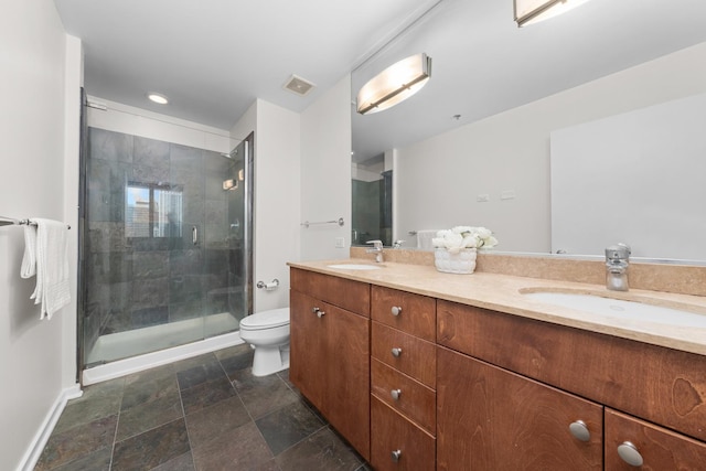 bathroom featuring a sink, a shower stall, toilet, and double vanity