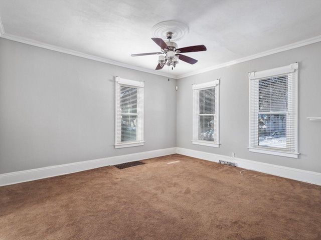 unfurnished room with a healthy amount of sunlight, baseboards, ornamental molding, and carpet flooring