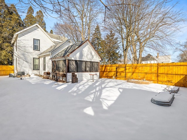 snow covered rear of property with fence