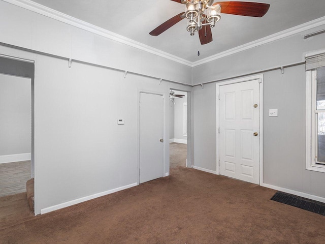 unfurnished bedroom featuring visible vents, baseboards, ceiling fan, ornamental molding, and dark carpet