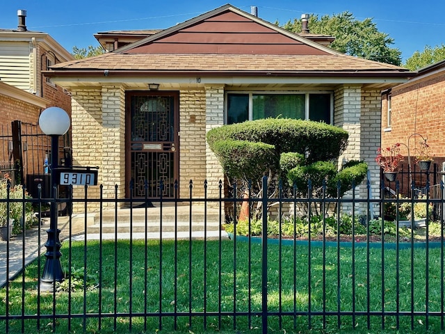 bungalow-style house with roof with shingles, brick siding, a fenced front yard, and a front yard