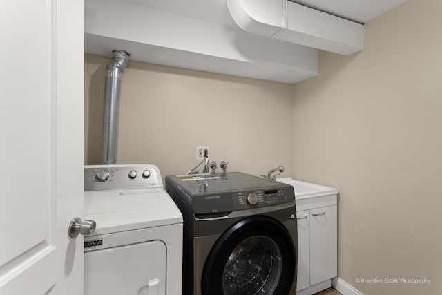 laundry area with cabinet space, a sink, washer and clothes dryer, and baseboards