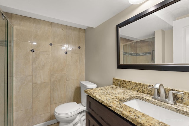 bathroom with toilet, a shower stall, and vanity