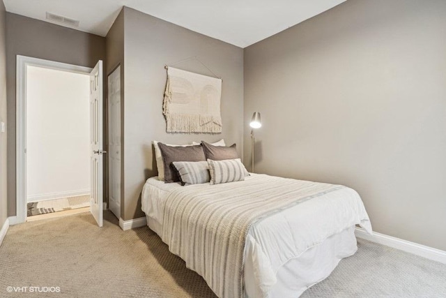 bedroom with light carpet, visible vents, and baseboards