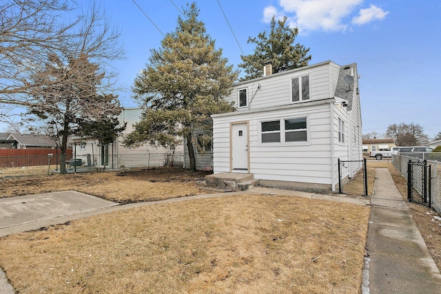 view of front of property featuring a gate, a chimney, and fence