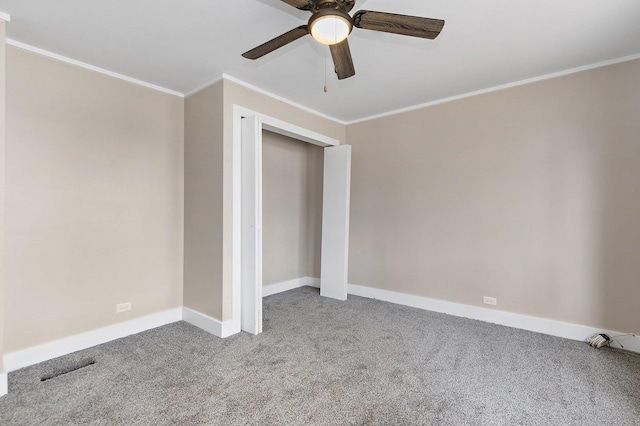 unfurnished bedroom featuring carpet, a closet, ornamental molding, a ceiling fan, and baseboards