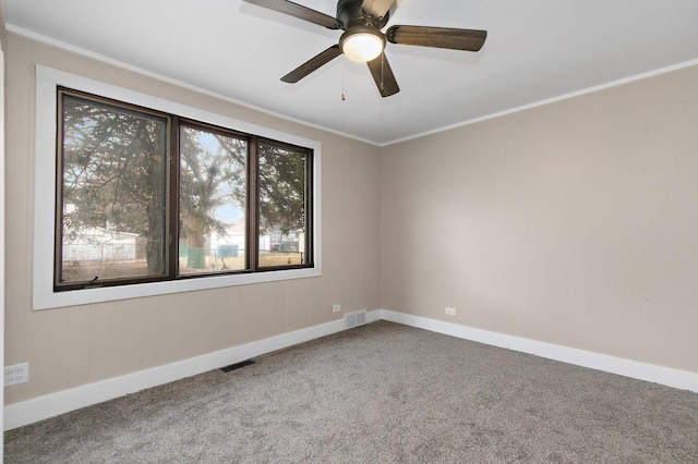 carpeted empty room featuring visible vents, crown molding, and baseboards