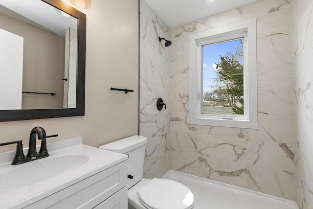 bathroom featuring toilet, vanity, and a marble finish shower