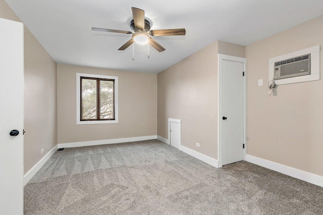 carpeted empty room featuring ceiling fan, baseboards, and a wall mounted AC